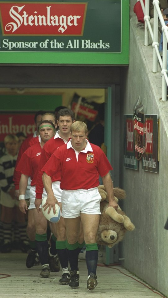 Peter Winterbottom of the British and Irish Lions leads the team out with another toy lion mascot 