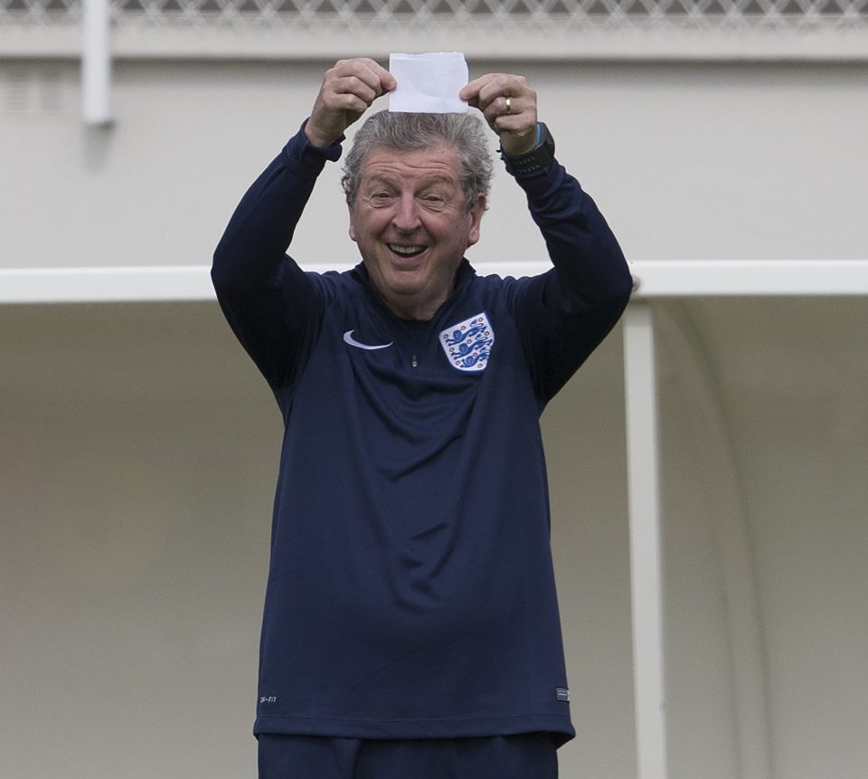 England boss Hodgson grins as he waves his secret notes towards the snappers