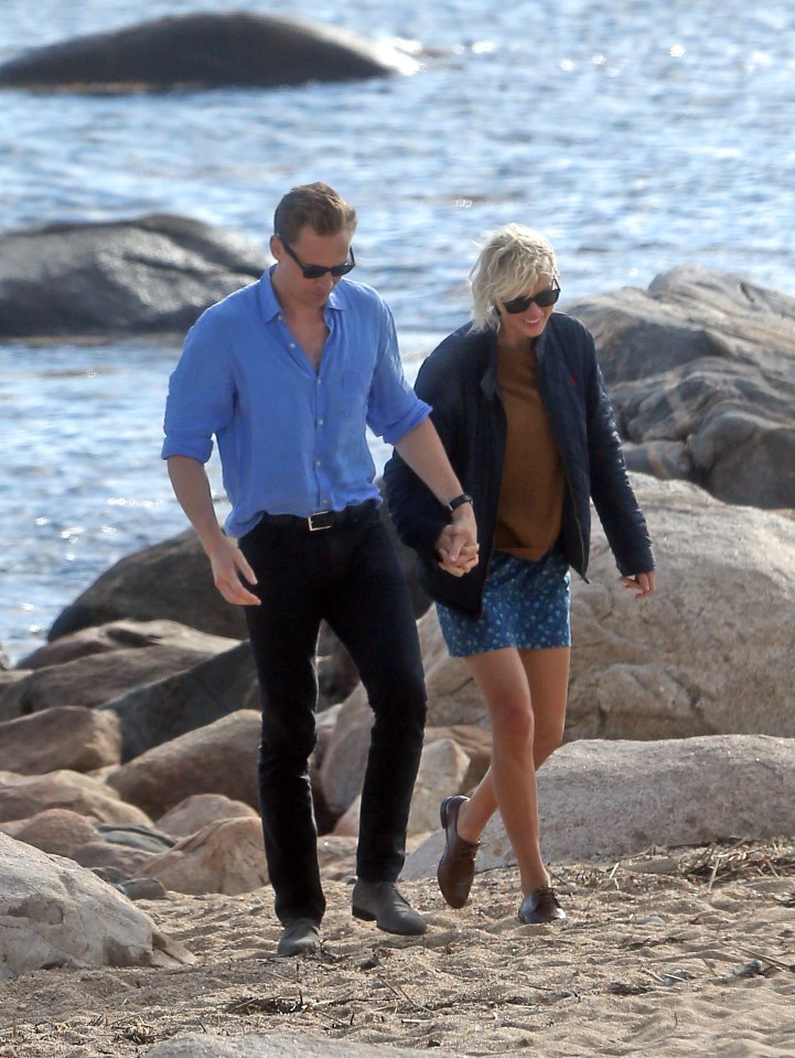 Taylor Swift and Tom Hiddlestone are deep in conversation holding hands walking along the beach at Westerly, Rhode Island 