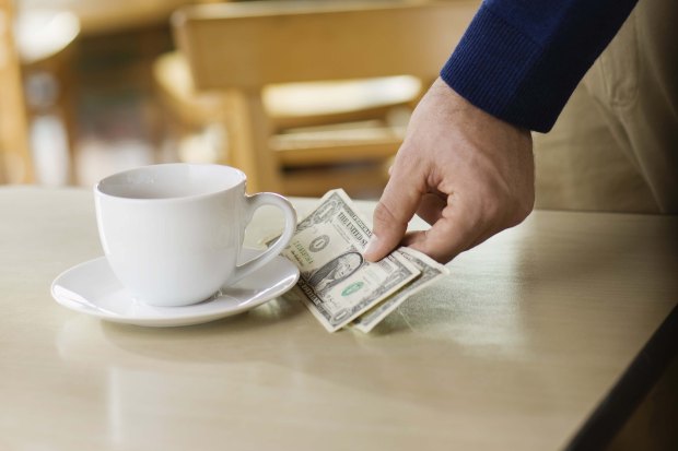 Man leaving tip on table at cafe