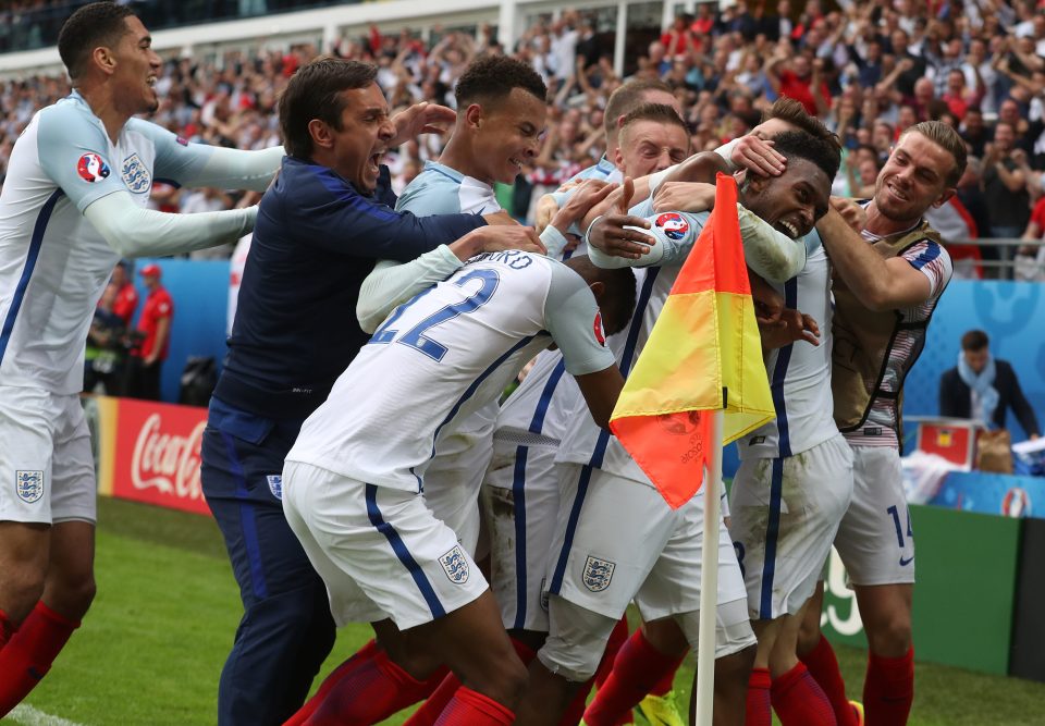 The England squad mob Sturridge as they celebrate his winning goal against Wales
