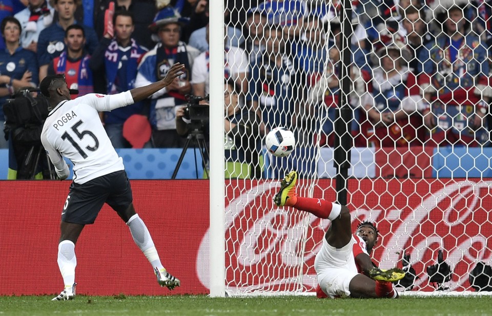 Switzerland's Johan Djourou, on the ground, goes for the ball with France's Paul Pogba