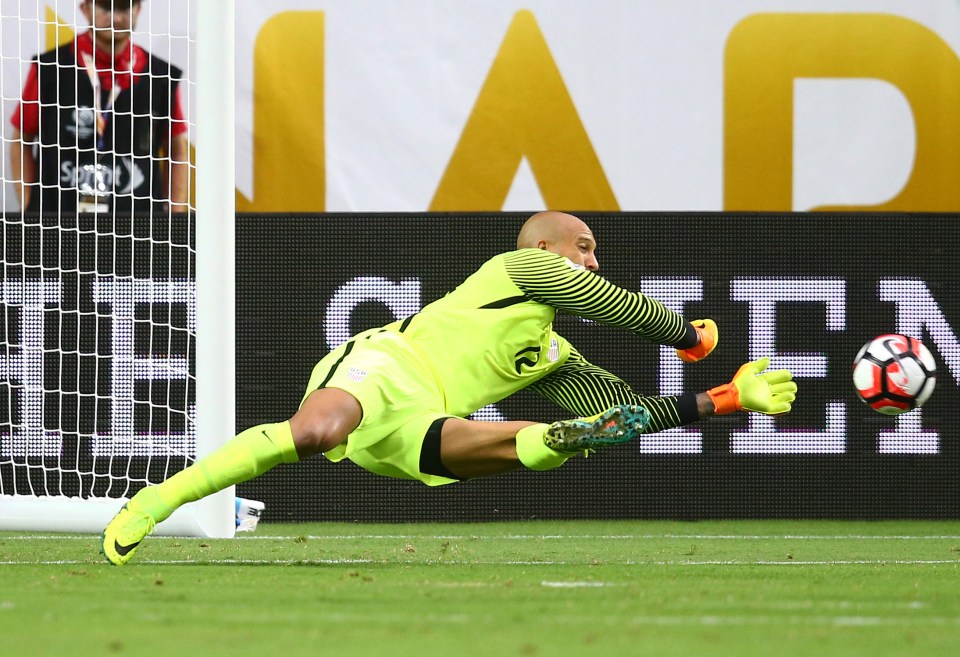 USA goalkeeper Howard saves a low shot to keep his team in the game