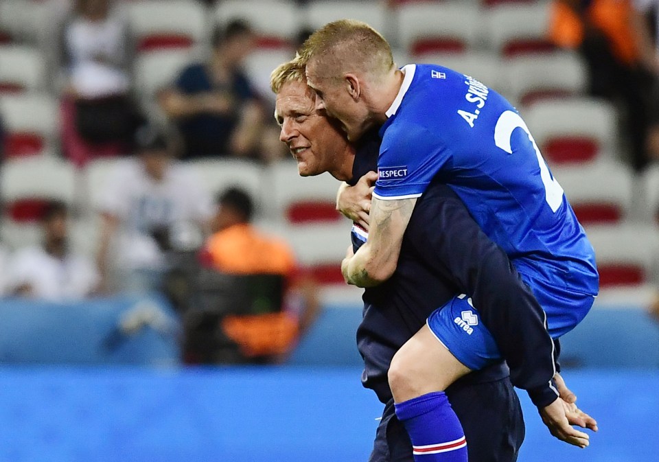 Coach Heimir Hallgrimsson carries Ari Skulason after the final whistle