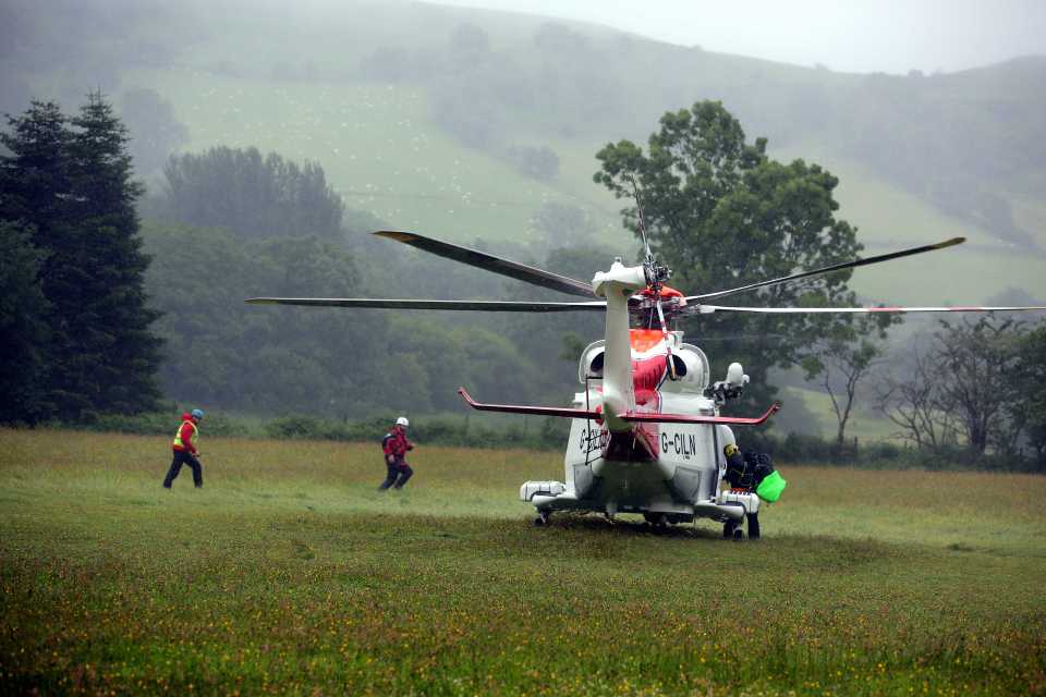 A Coastguard helicopter lands in a field 