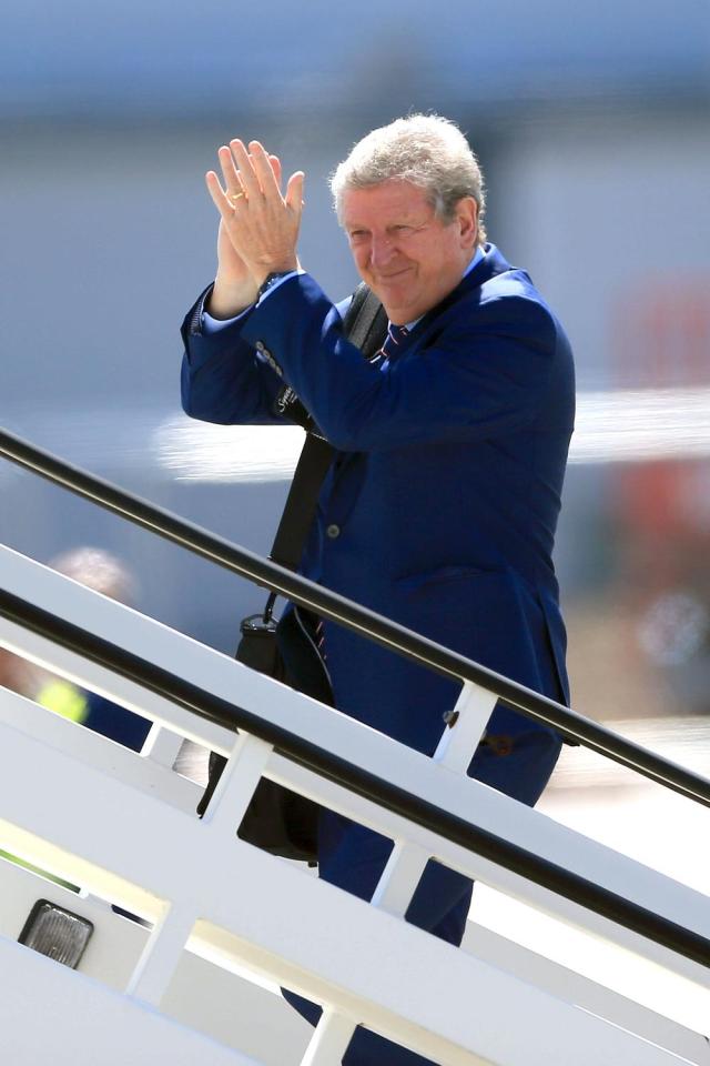 Roy Hodgson applauds well-wishers as he boards the flight
