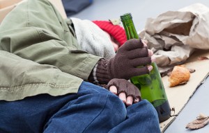 Homeless alcoholic with bottle of wine on a street