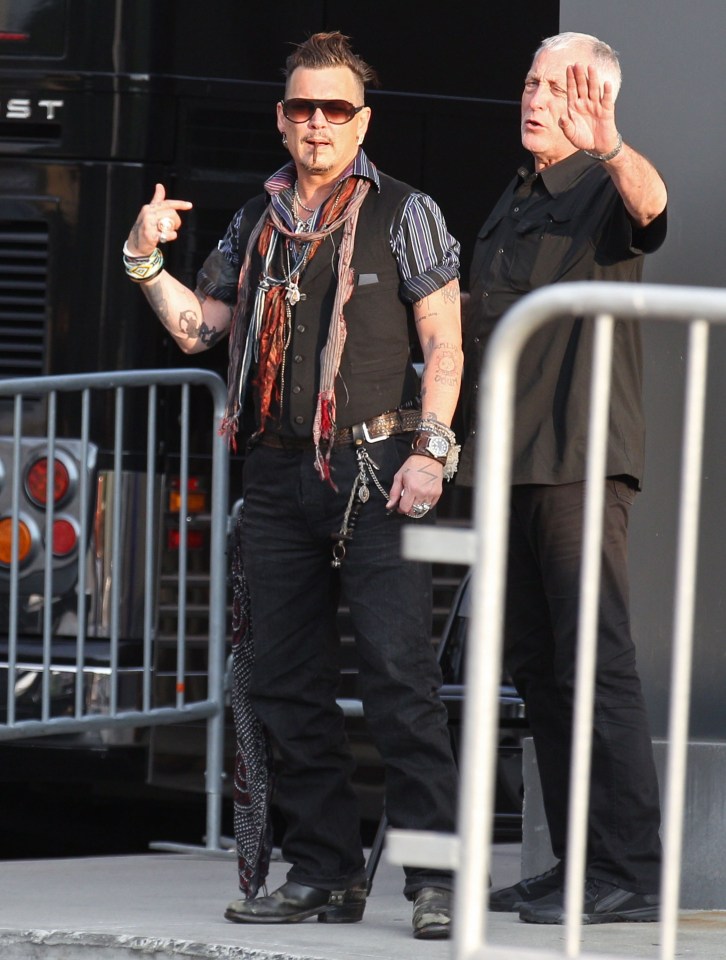 Who me? Johnny jokes with fans as he heads backstage to prep for his gig 