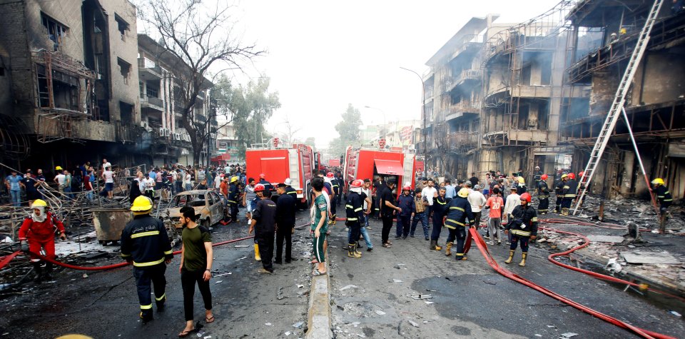 Locals and emergency services gather at the scene of the bombing this morning