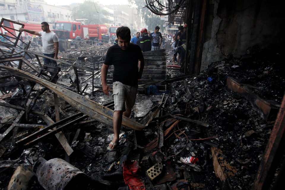 A man makes his way through the charred rubble following the bombing