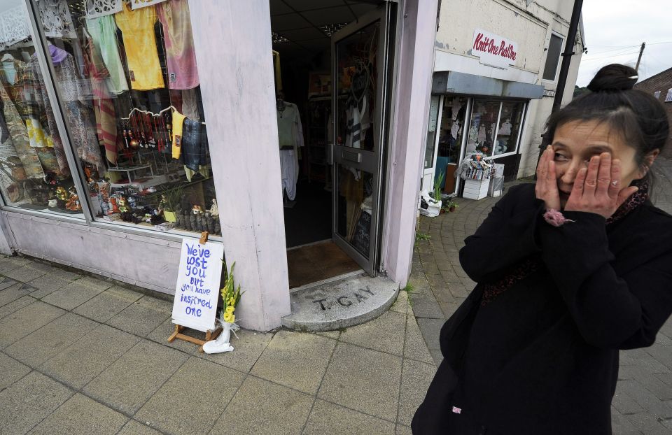 A shopkeeper in Heckmondwike reacts as the cortege for Labour MP Jo Cox makes its way through the town in West Yorkshire, ahead of her private funeral service