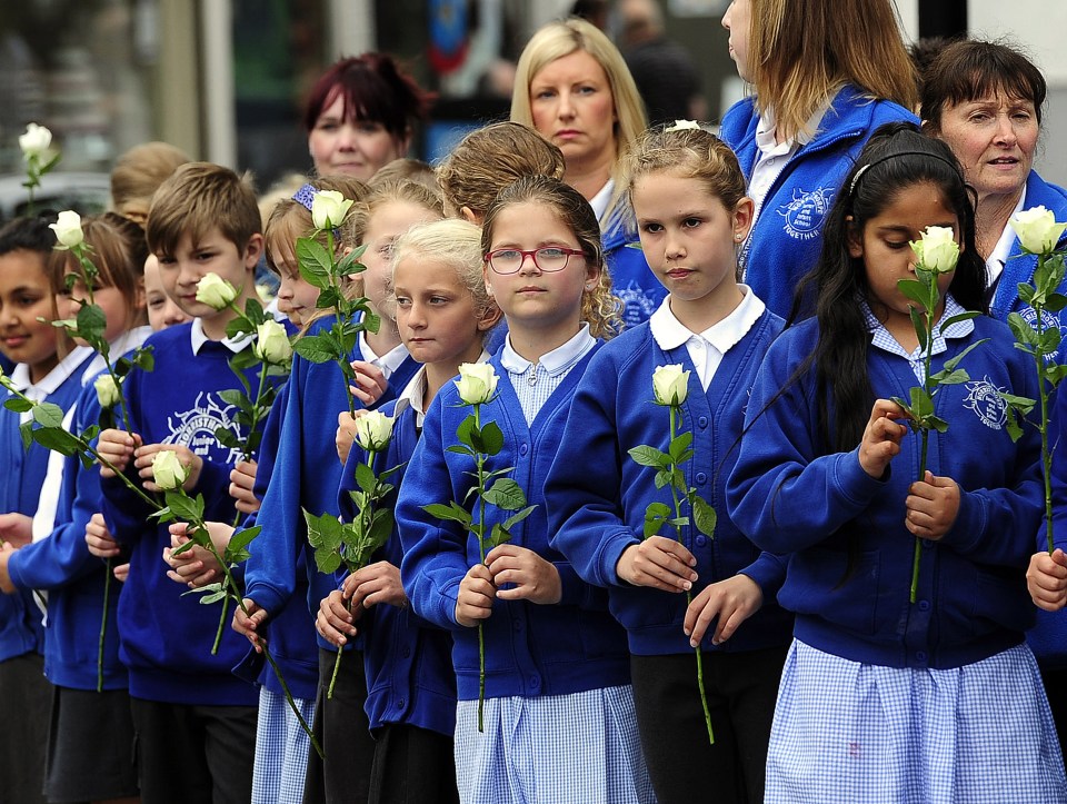 Schoolchildren from Norristhorpe Primary wait to throw flowers onto the funeral cortege for Jo Cox as it passes though their hometown