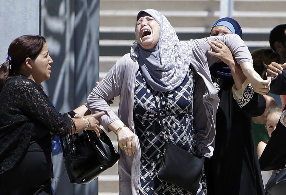 A woman reacts after learning of the death of a relative, outside the Pasteur hospital in Nice