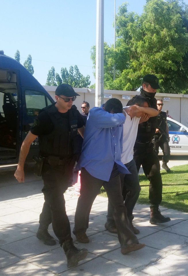 Greek police officers escort Turkish military officers at the court of Alexandroupolisc in Greece