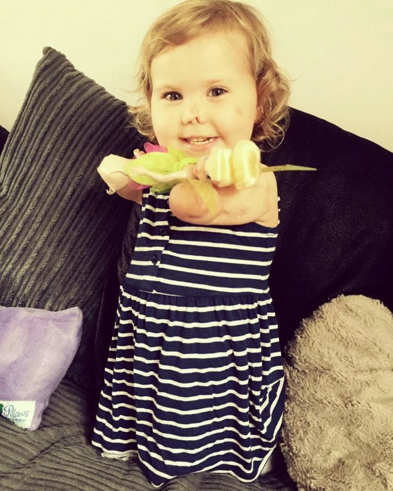 The determined tot who lost all her limbs can be seen clutching a pen and drawing 