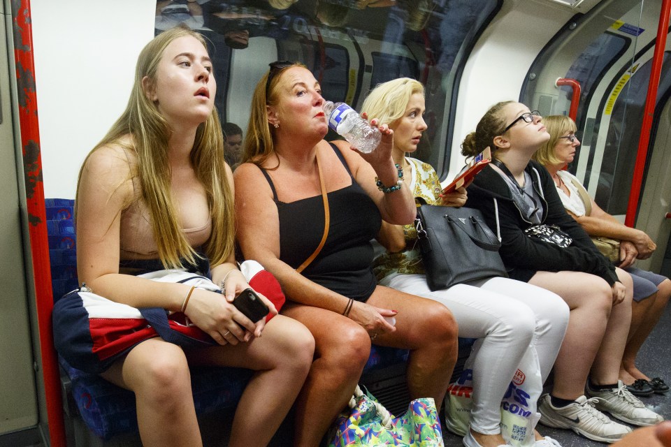 People drink water to stay cool while travelling on the tube in central London when temperatures hit 27C degrees across the capital 