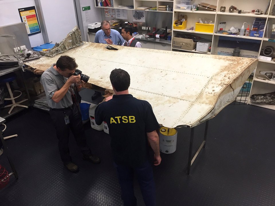 Australian and Malaysian officials examine aircraft debris that was found near Tanzani