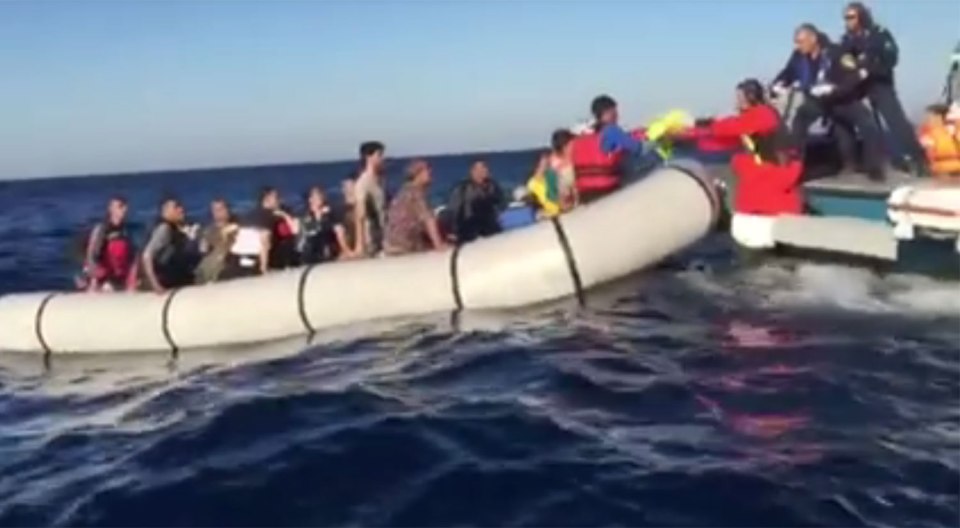 The baby's parents stretch her out as the boats are rocked by waves