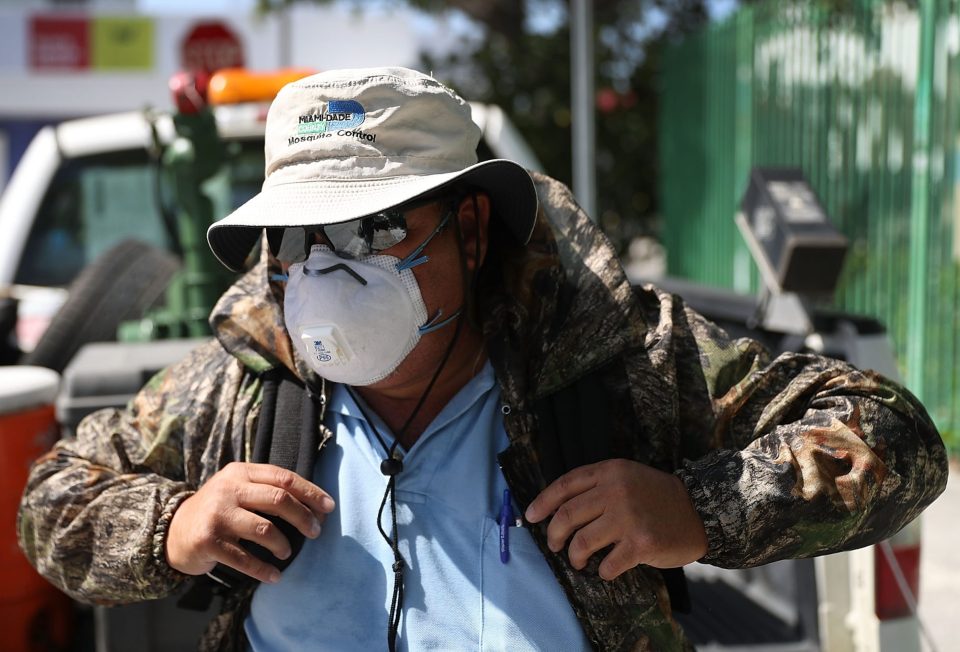 Robert Muxo, a Miami-Dade County mosquito control inspector, prepares to use a fogger to spray pesticide to kill mosquitos