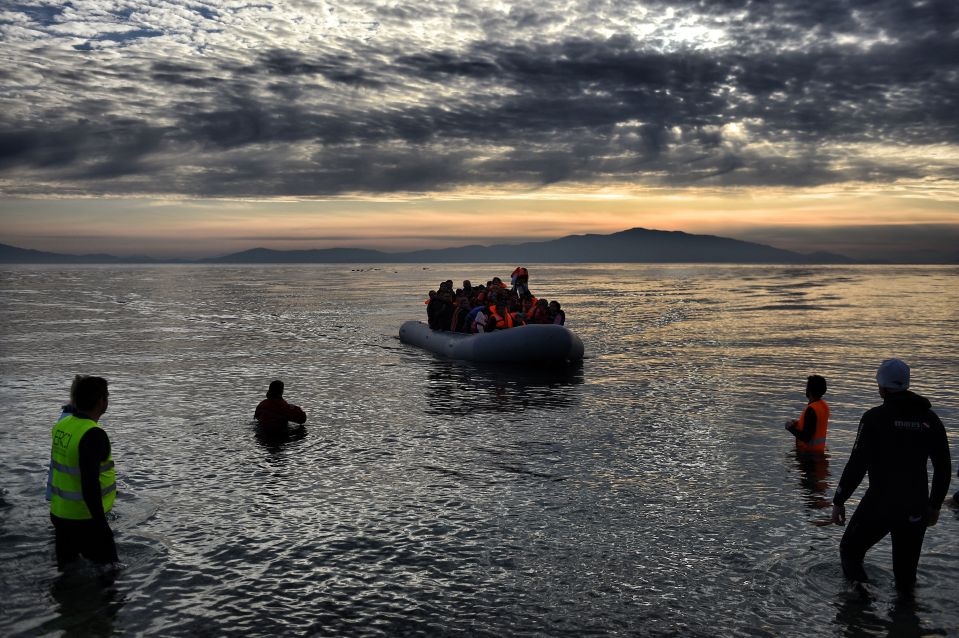 Refugees and migrants on a rubber boat arrive at the northern island of Lesbos after crossing the Aegean sea