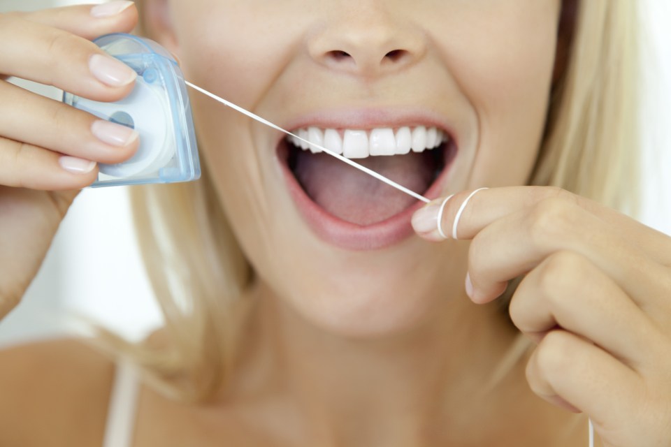 We spend over 730 minutes a year flossing Flossing could be a complete waste of time (Picture posed by model)