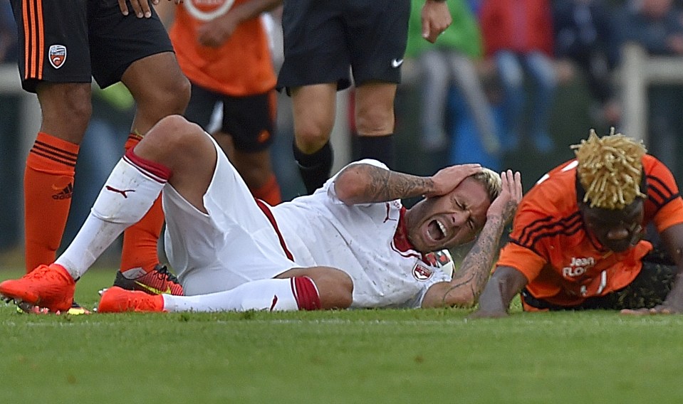 Menez grimaces in pain after his ear is sliced in half
