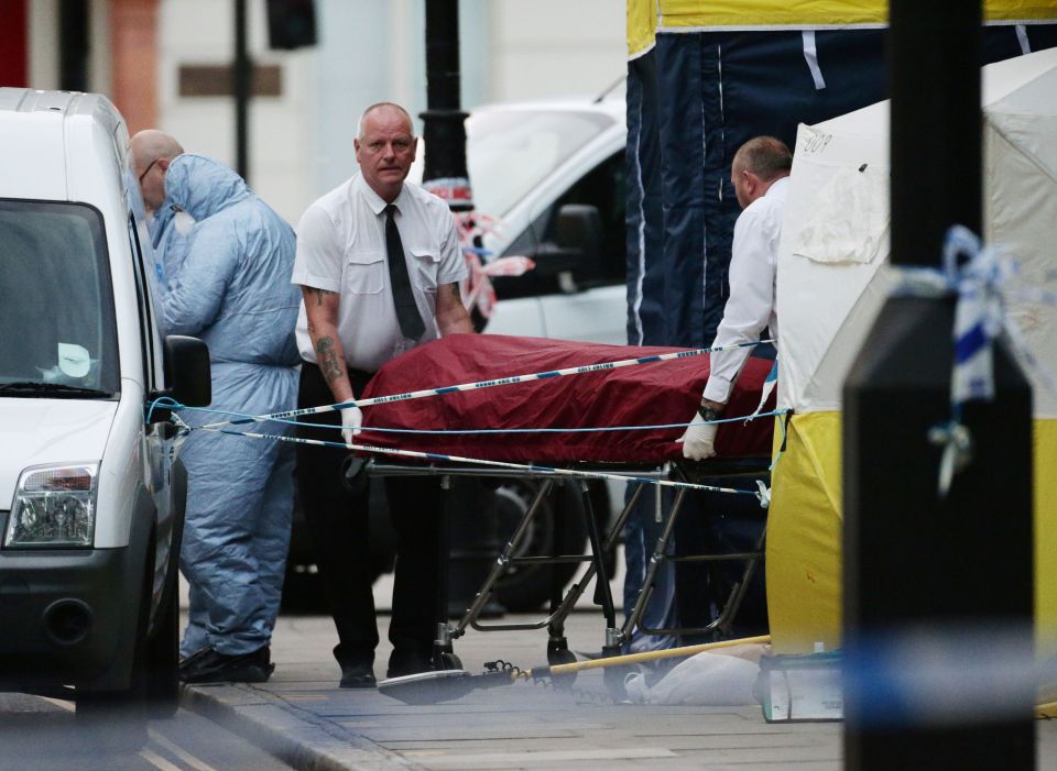 A body is removed from the scene in Russell Square, central London, after a knife attack in which a woman in her 60s was killed and five people were injured