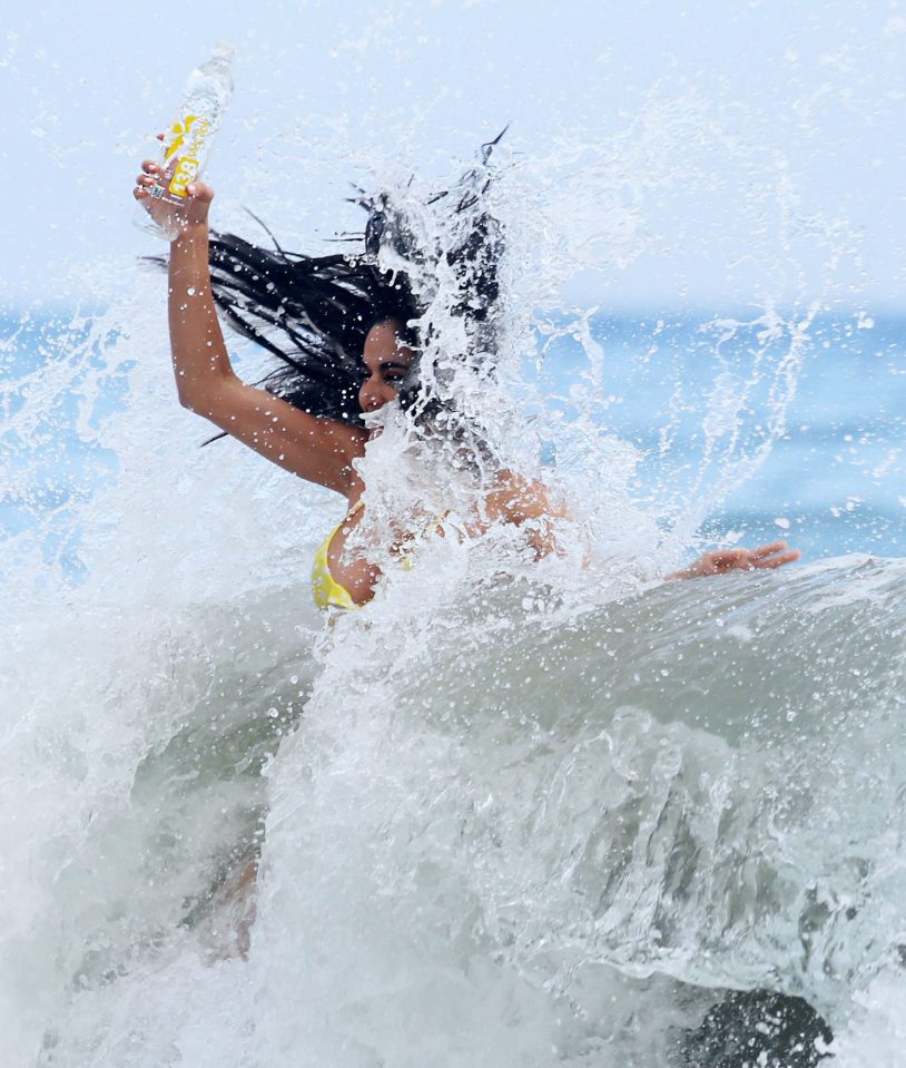 The brunette struggled to stand as she was hit by a wave