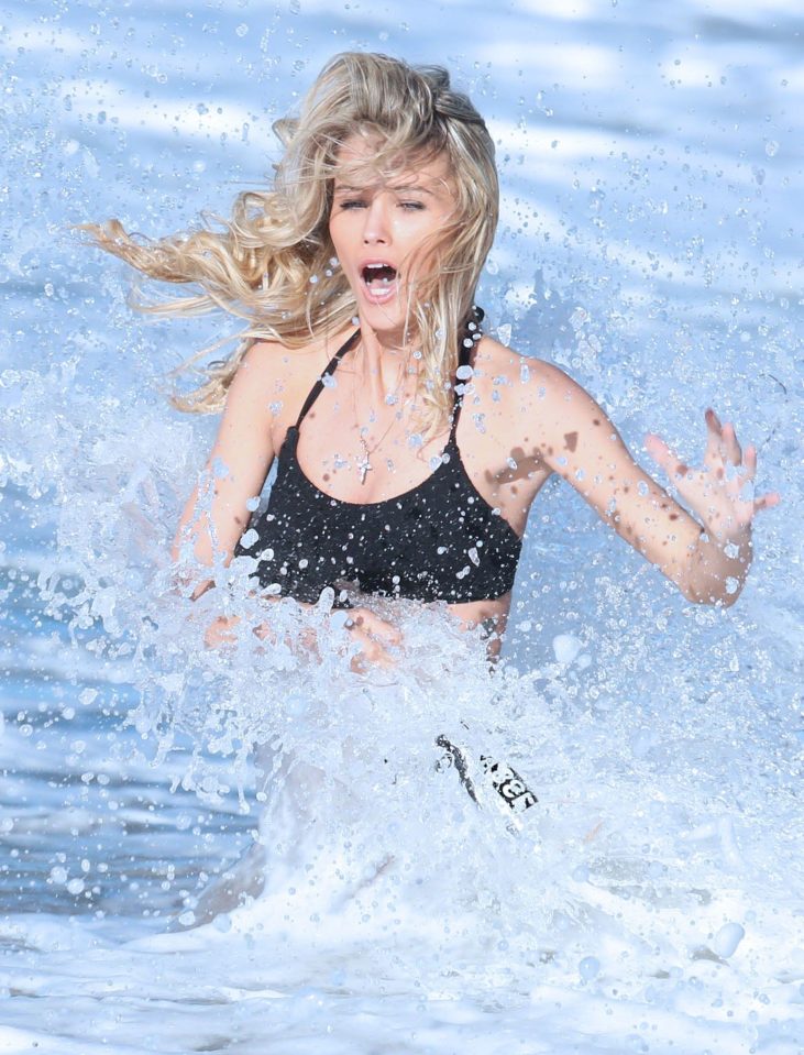 Her racy pose is ruined by a giant wave