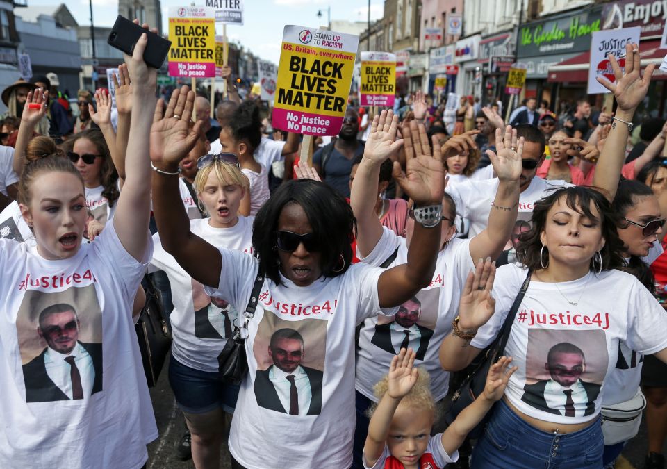 Protesters hold up placards and chant as