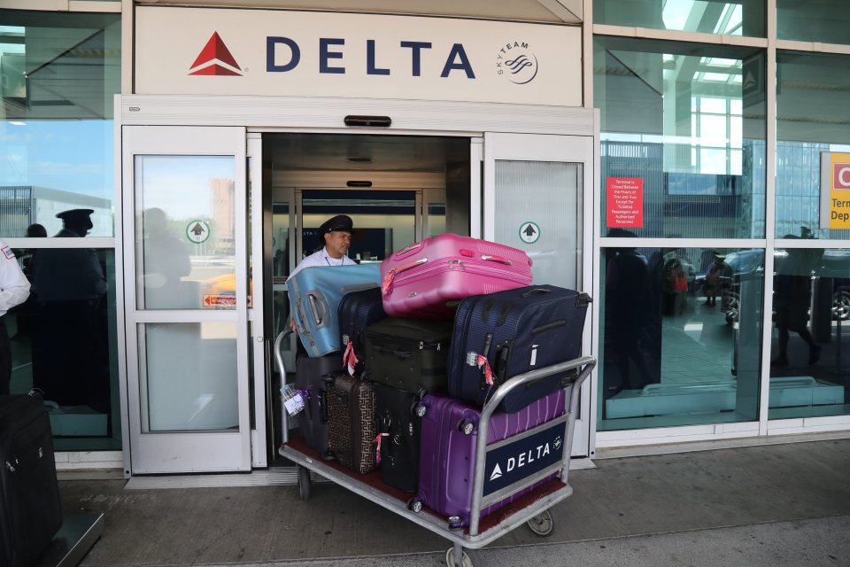 US airline 'Delta' baggage handler moves passenger luggage as mass confusion increased over whether or not passengers would be able to fly