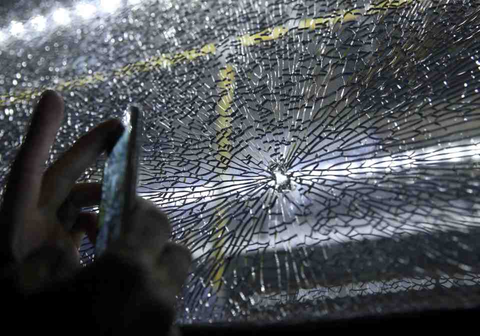 A broken window on an official media bus after it shattered in Rio de Janeiro