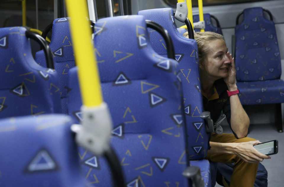 Journalist Joanna Moyse cries on an official media bus after a window shattered in Rio de Janeiro