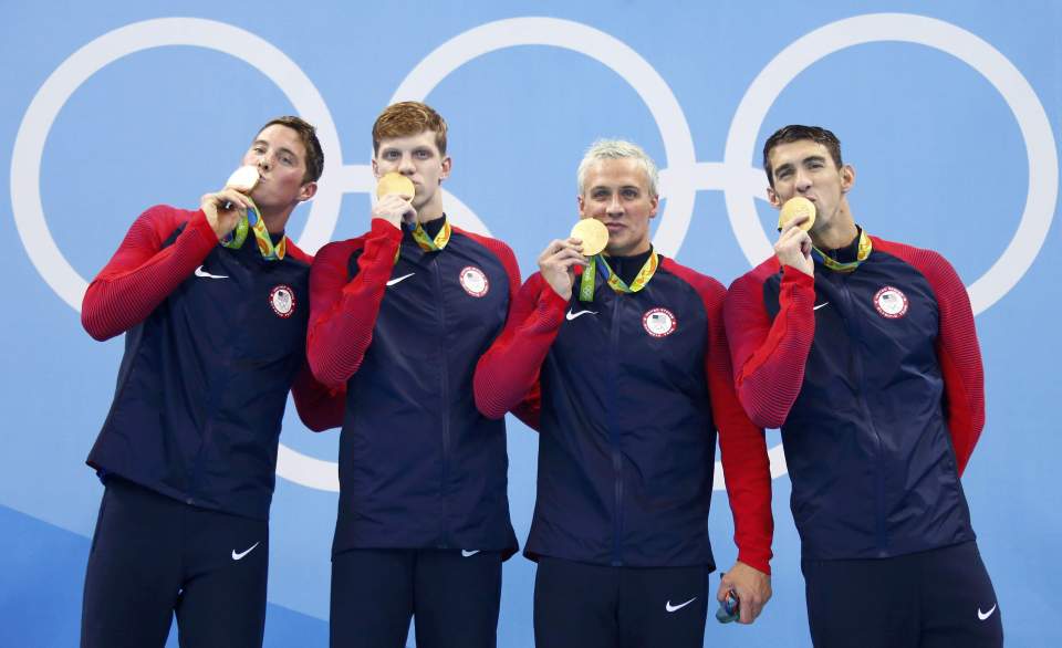 The USA team stand on the top step after their 4x200m freestyle relay victory