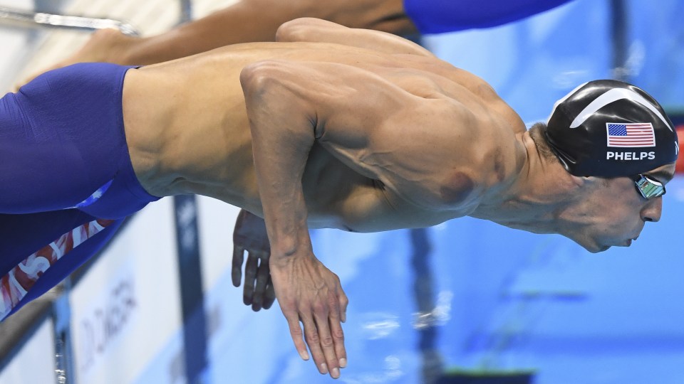 Michael Phelps dives in the pool before winning his latest gold medal