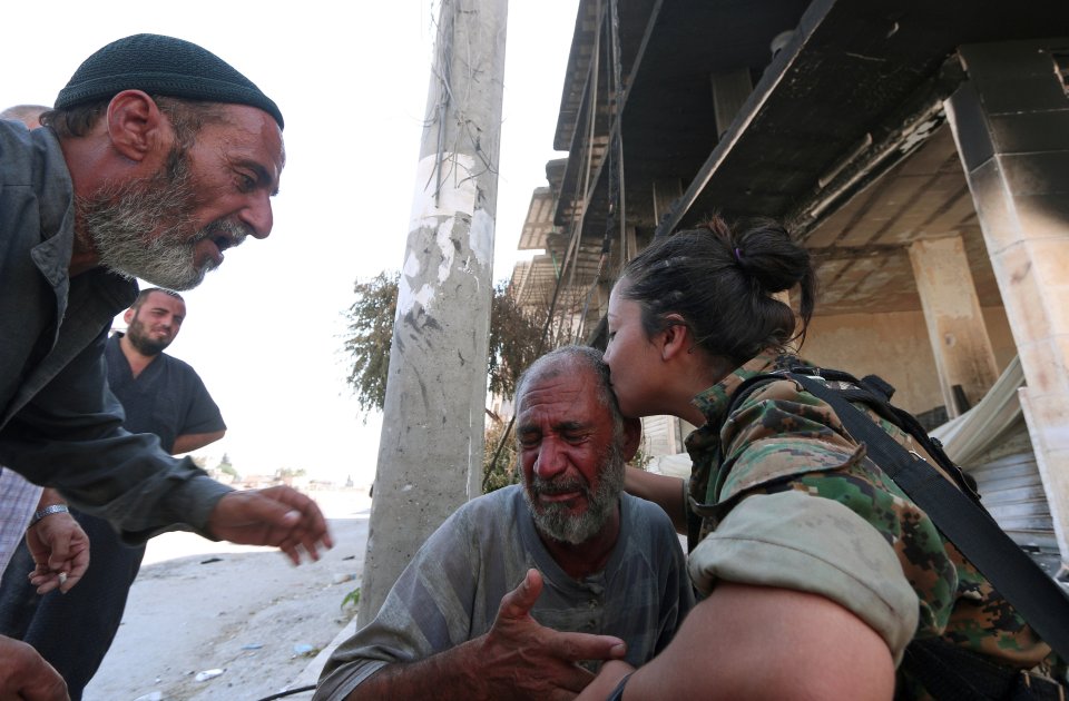 A Syria Democratic Forces (SDF) fighter comforts a civilian who was evacuated with others by the SDF from an Islamic State controlled neighbourhood of Manbij, in Aleppo Governorate