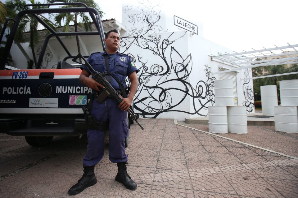 A cop stands guard outside the entrance of the restaurant in Puerto Vallarta where the kidnapping occurred