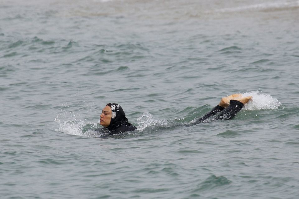 A Muslim woman wears a burkini, a swimsuit that leaves only the face, hands and feet exposed, as she swims in the Mediterranean in Marseille