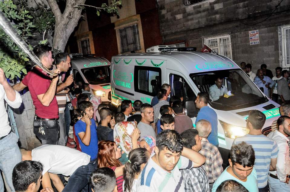 People gather near the explosion which ripped through a narrow street as wedding guests danced 