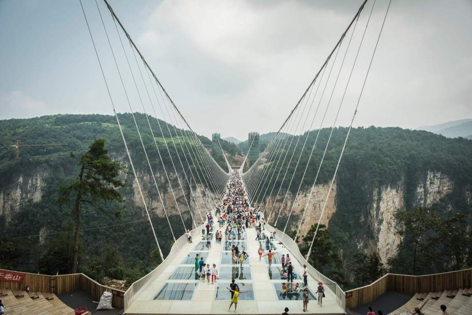 Visitors cross the world's highest and l
