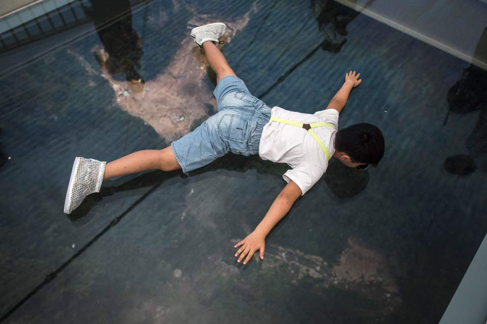 A boy lies down to see the view through