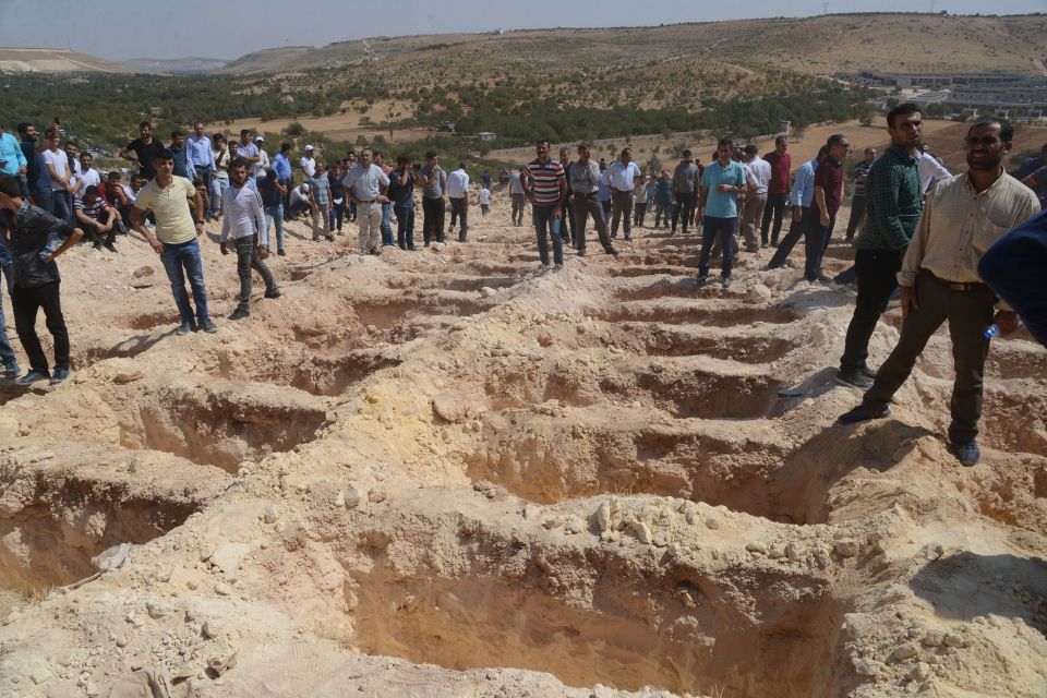 Haunting pictures show the mass graves dug for the 51 people killed as they danced at a wedding