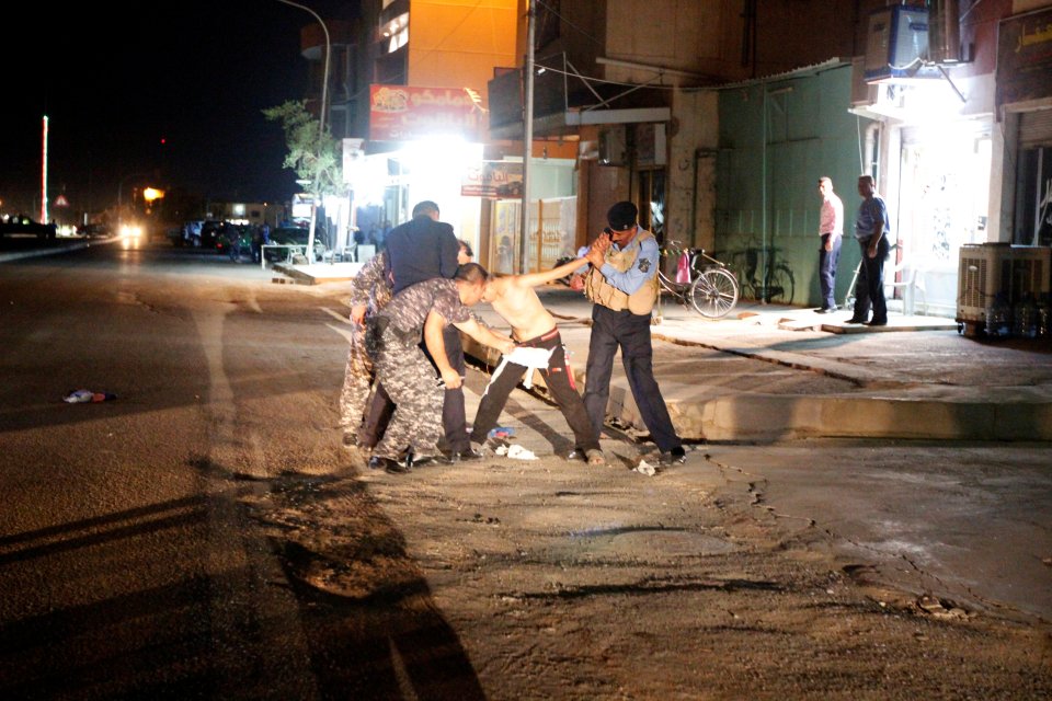 Iraqi security forces remove a suicide vest from a boy in Kirkuk