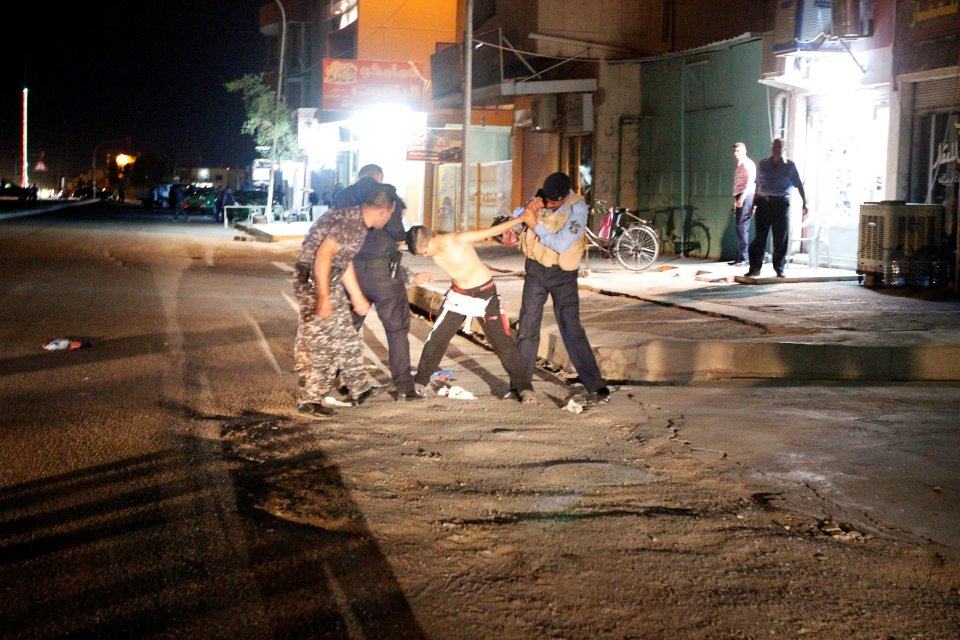 Iraqi security forces remove a suicide vest from a boy in Kirkuk
