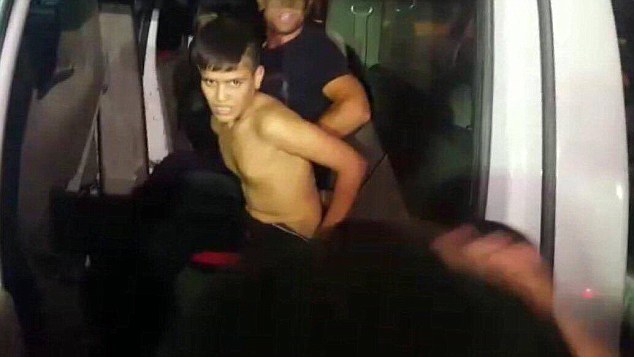 The young boy is led away after being arrested by the brave policemen