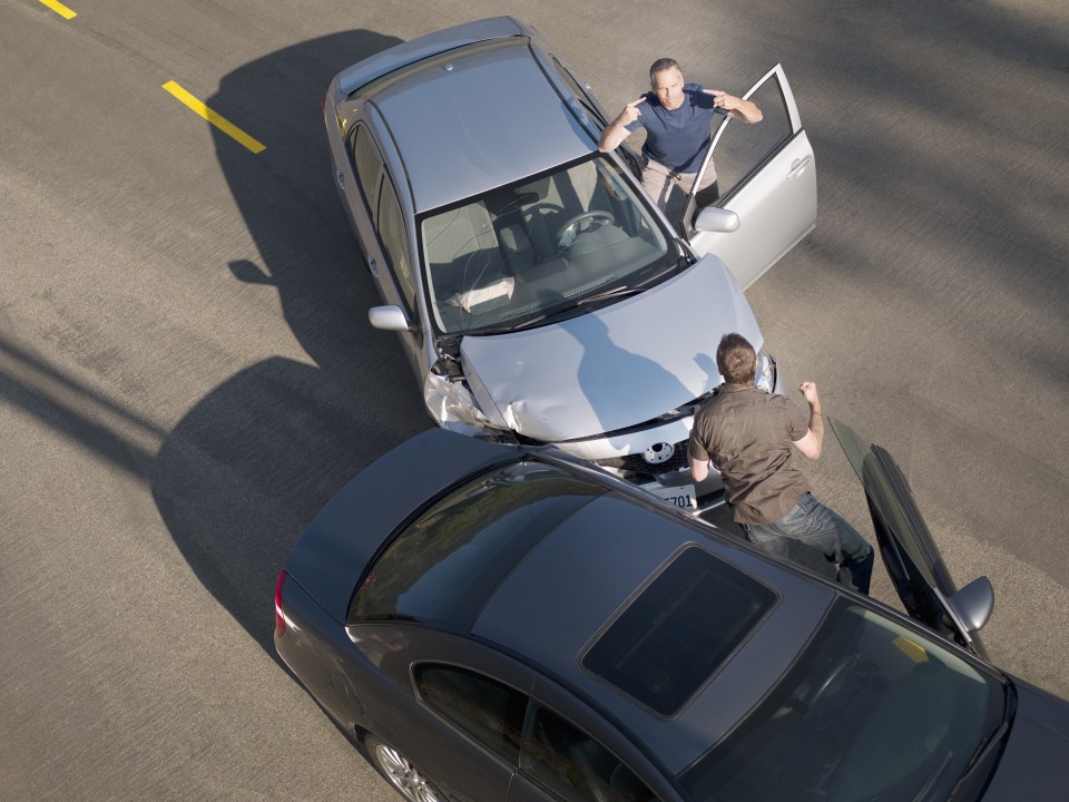 Two men arguing about damage in car collision