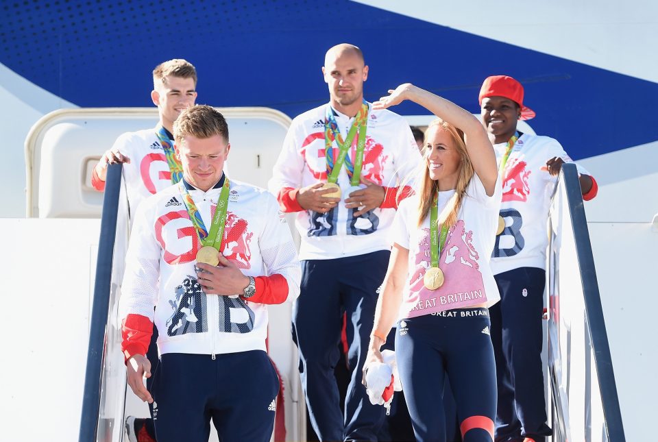 Rower Helen Glover waves as she walks down the stairs at Heathrow