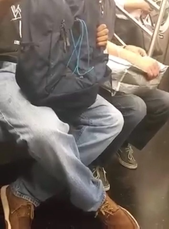 The man is at first seen to be holding a bag on his lap