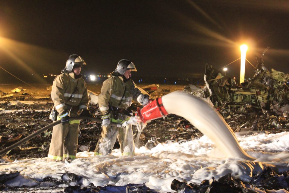 Rescuers extinguishing fire at the site of the crash