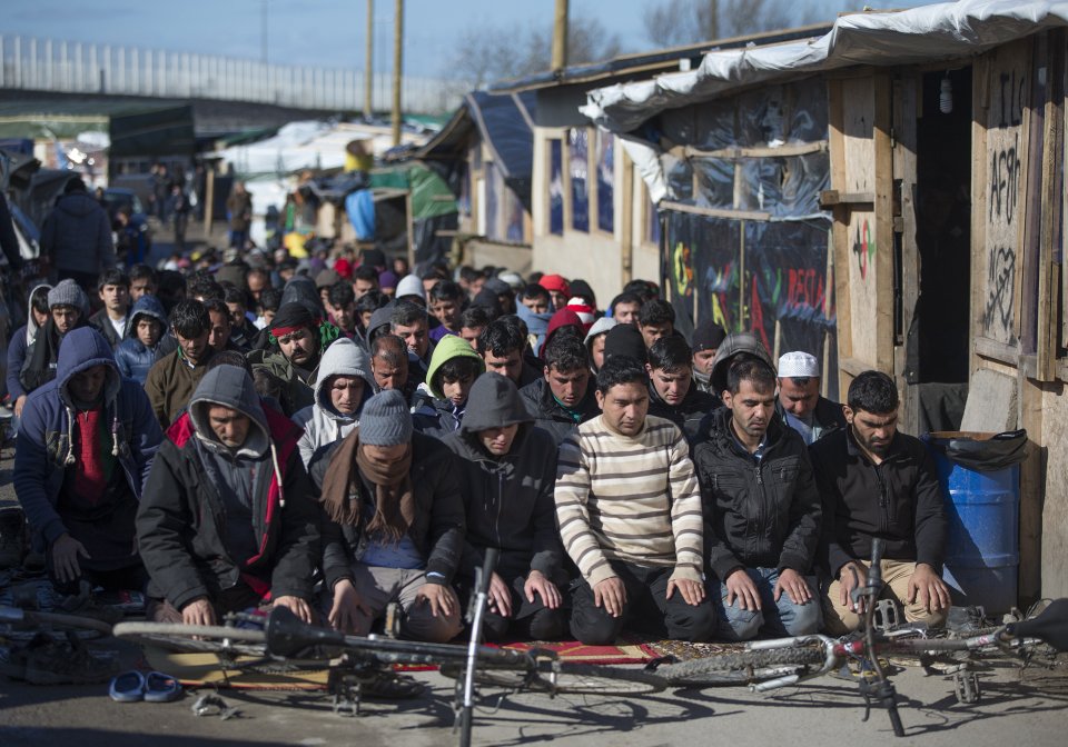 Muslim migrants pray during Friday prayer next to makeshift shelters as the dismantlement of the shanty town called the "Jungle" continues in Calais